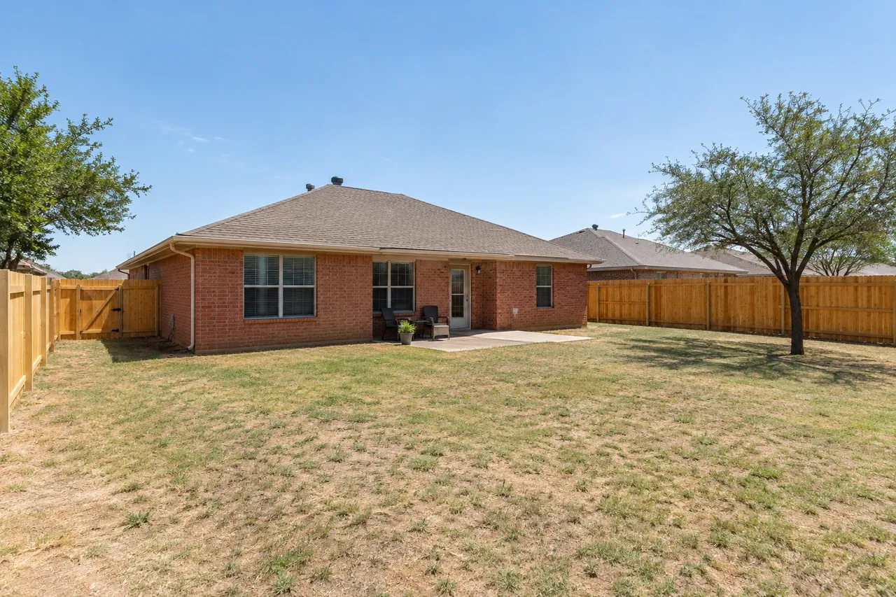 New cedar privacy fence behind a brick ranch home in Lubbock