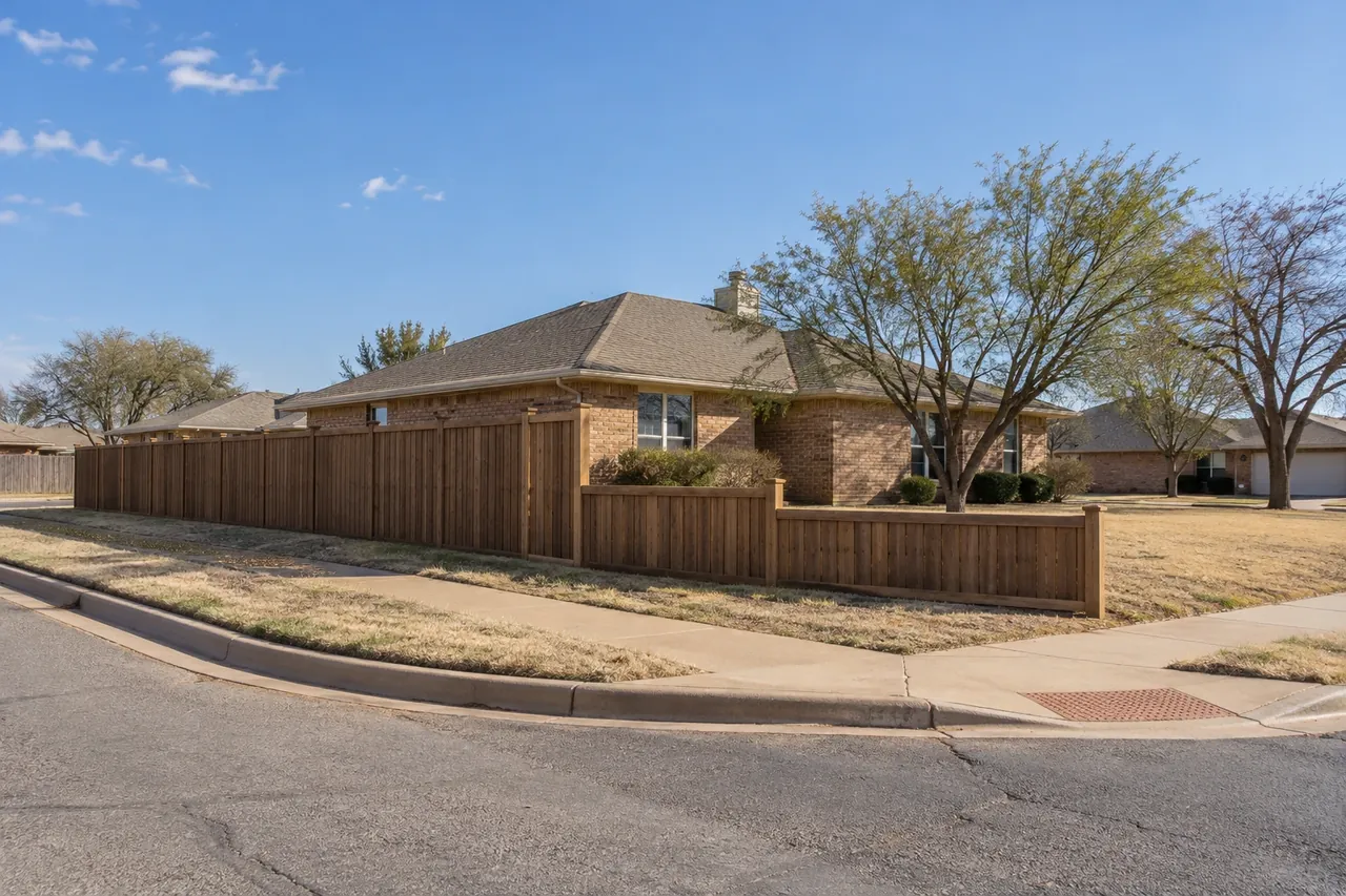 Fence stepping down near the corner of a Lubbock residential lot to keep the sight triangle clear